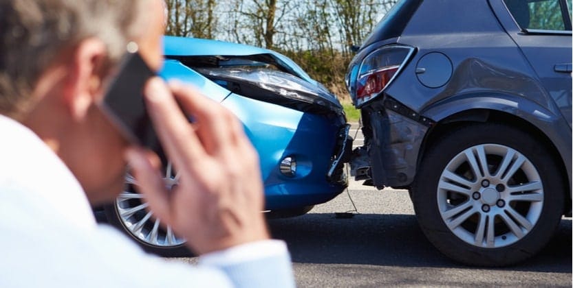 Man calling insurance company after a rear end collision in an SUV