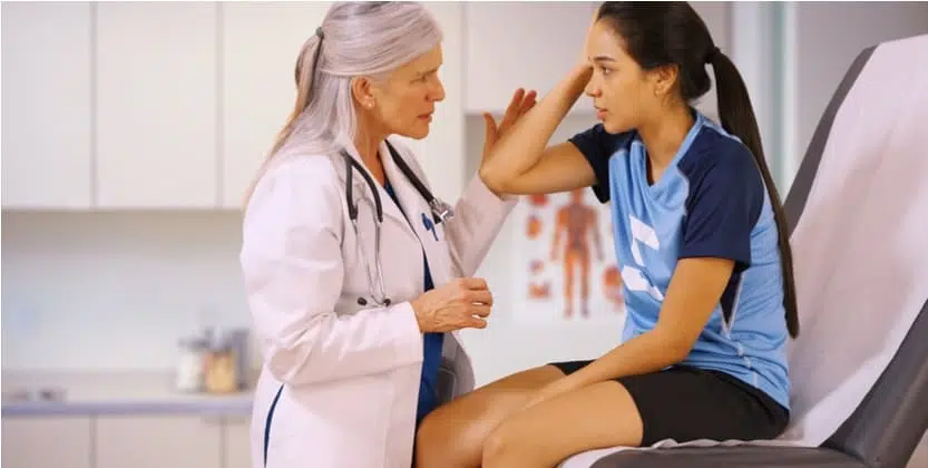 Female student athlete visiting doctor after injury