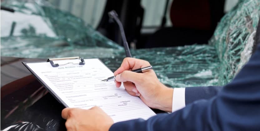 Man filling out an accident report after a car crash