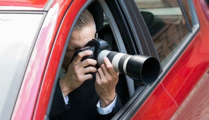 Personal injury law firm investigator taking photos from vehicle window