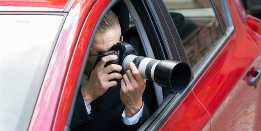 Personal injury law firm investigator taking photos from vehicle window