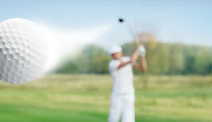 Man hits an errant golf ball on the golf course