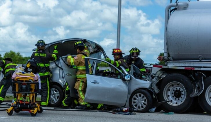 Broward County emergency services rescuing car accident victim from damaged vehicle