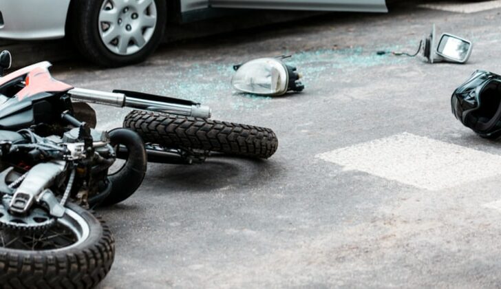 Shattered glass and crumpled motorcycle after a motorcycle accident