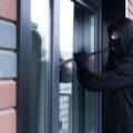 A burglar man tries to break the door lock and get into the apartment for robbery