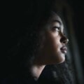 Close-up portrait of sad mixed-race teenager girl standing, bullying concept.