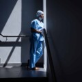 Female surgeon looking through the window in the hospital stairs