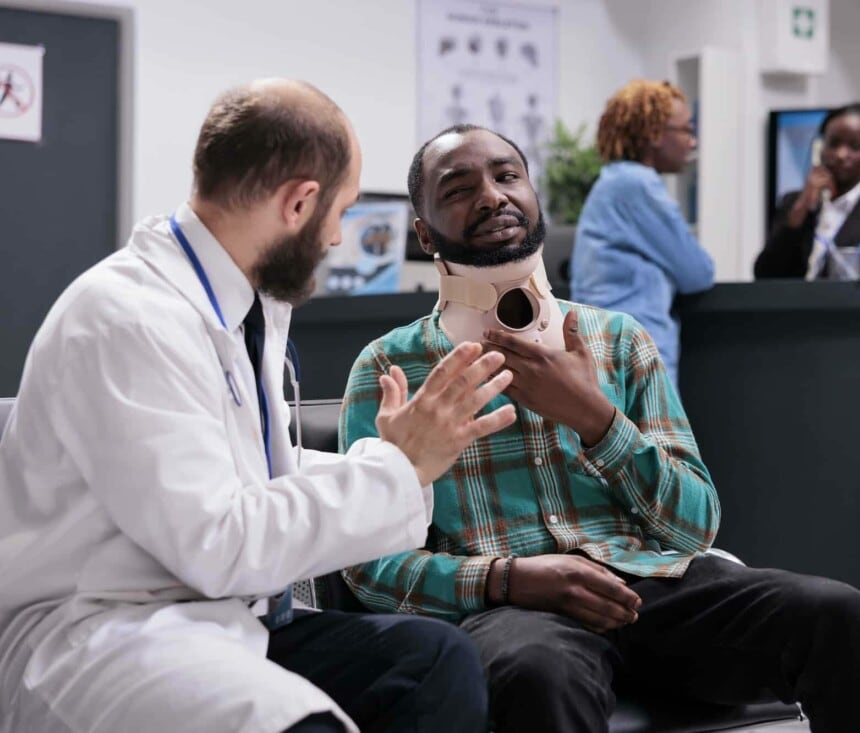 Injured person with neck collar talking to doctor