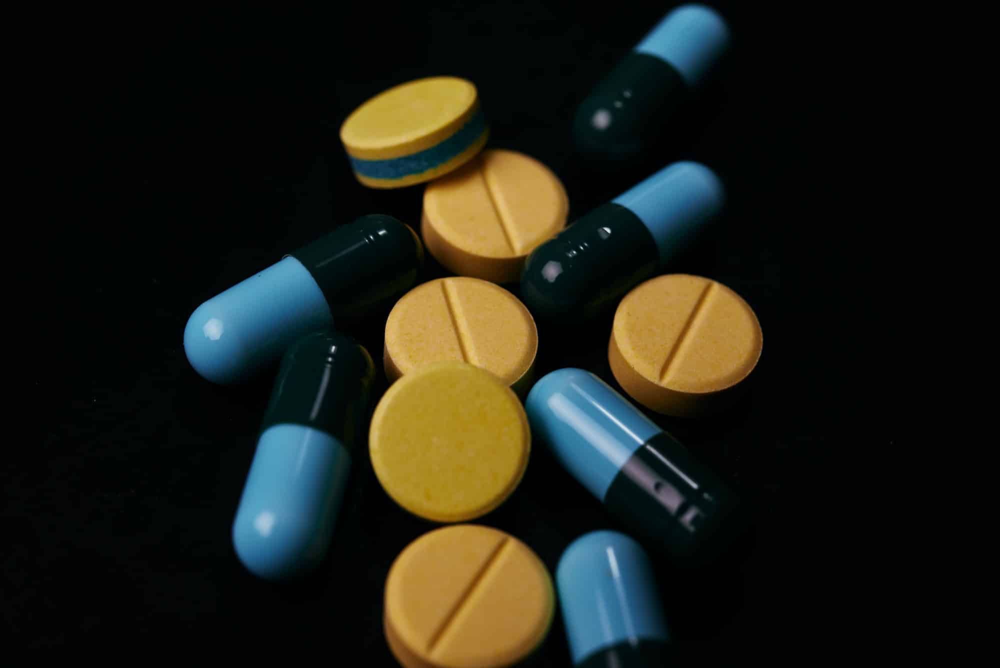 Pill and drug on black background