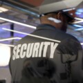 Security guard standing inside a commercial building nearby the window reflecting light