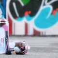 Several used spray cans with pink and white paint and caps for spraying paint under pressure is lies