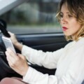 Woman using mobile phone while driving