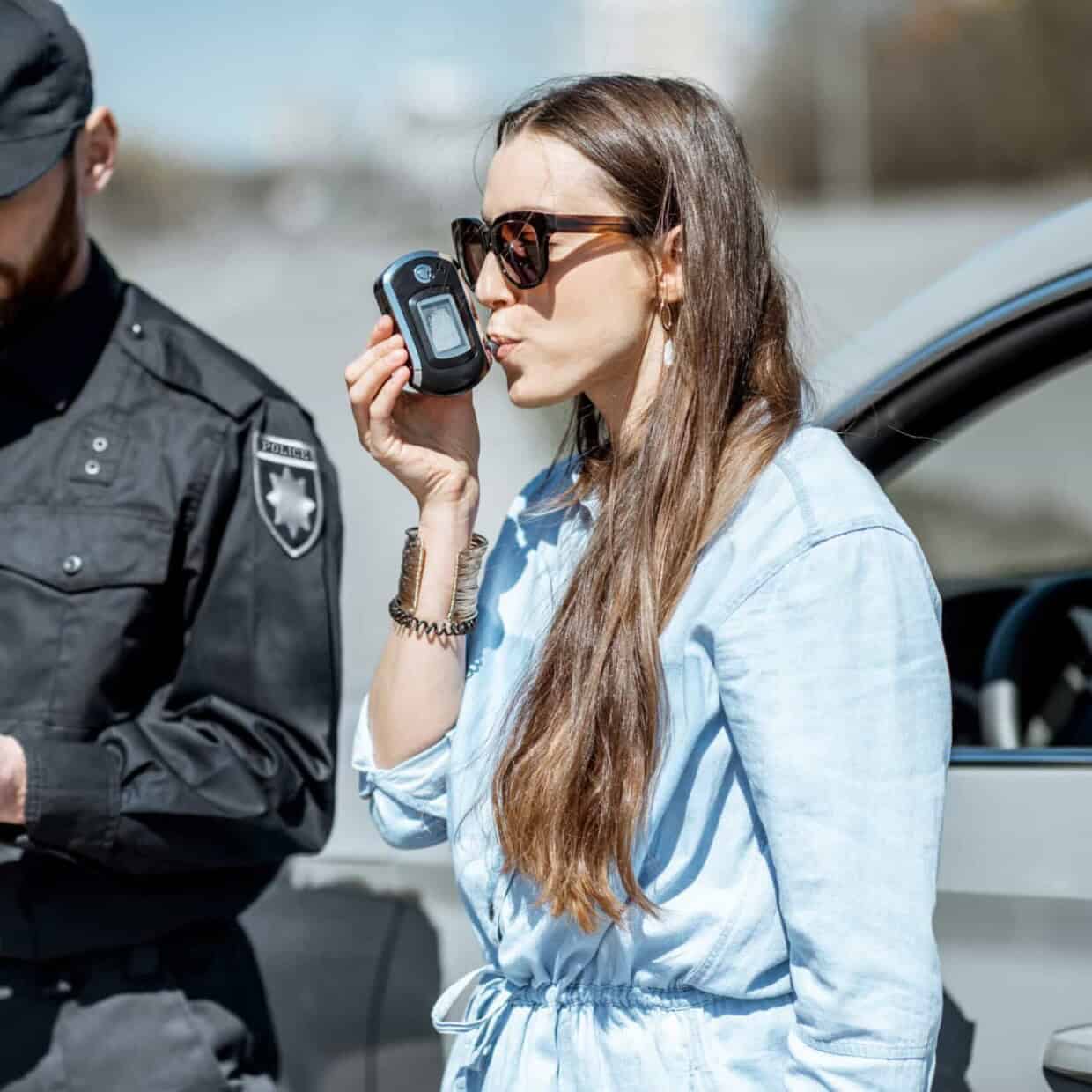Policeman checking woman driver for alcohol intoxication