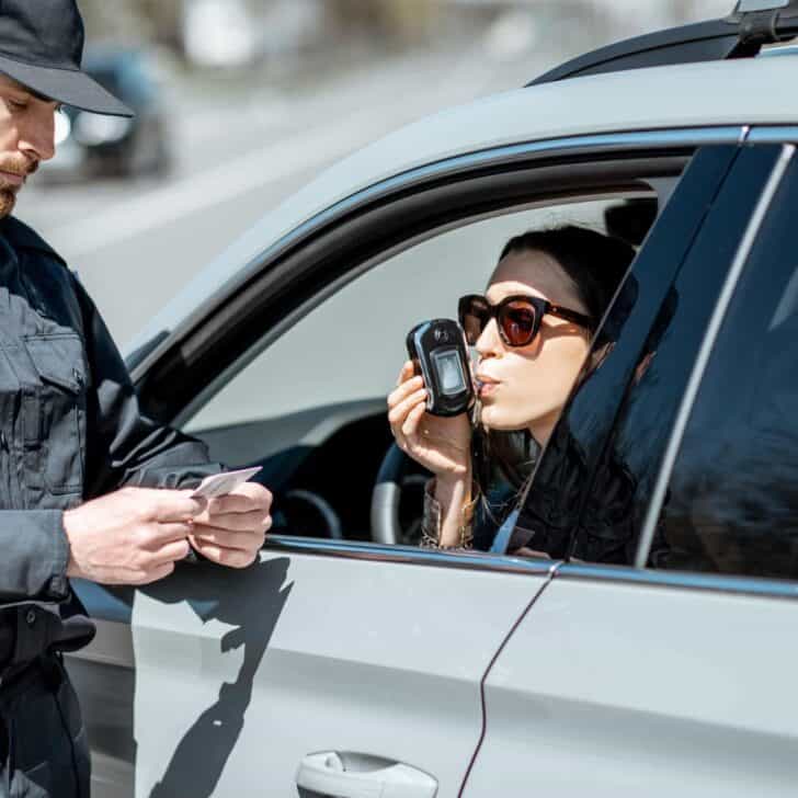 Policeman checking woman driver for alcohol intoxication