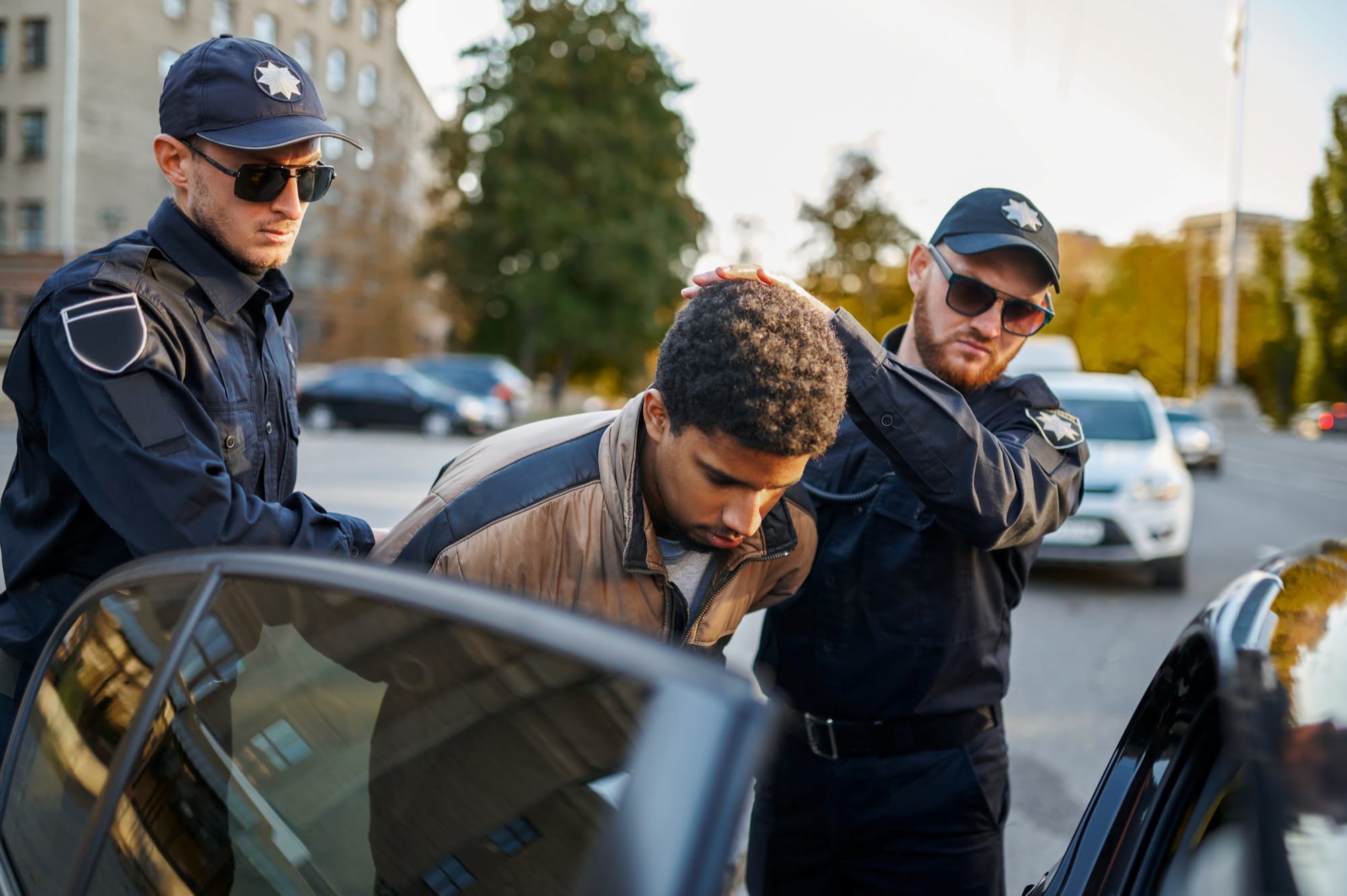 two male police officers arrest young man