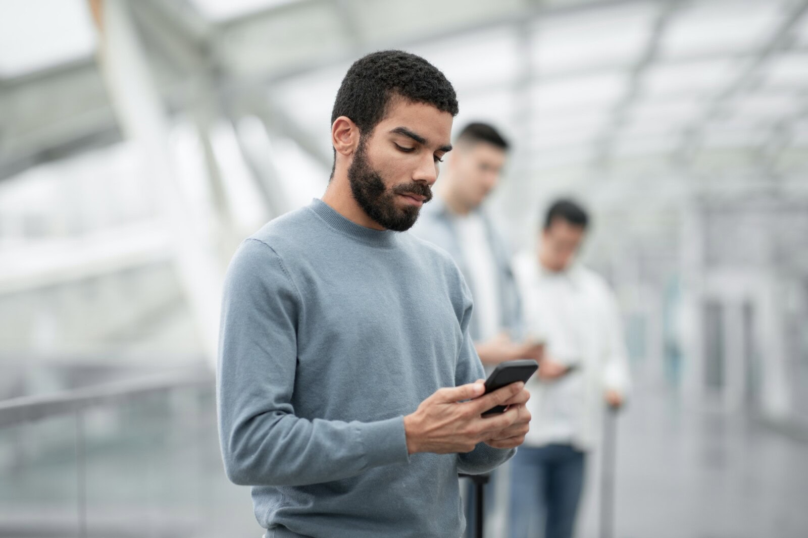 Middle Eastern Tourist Man Using Cellphone Texting In Airport Indoors