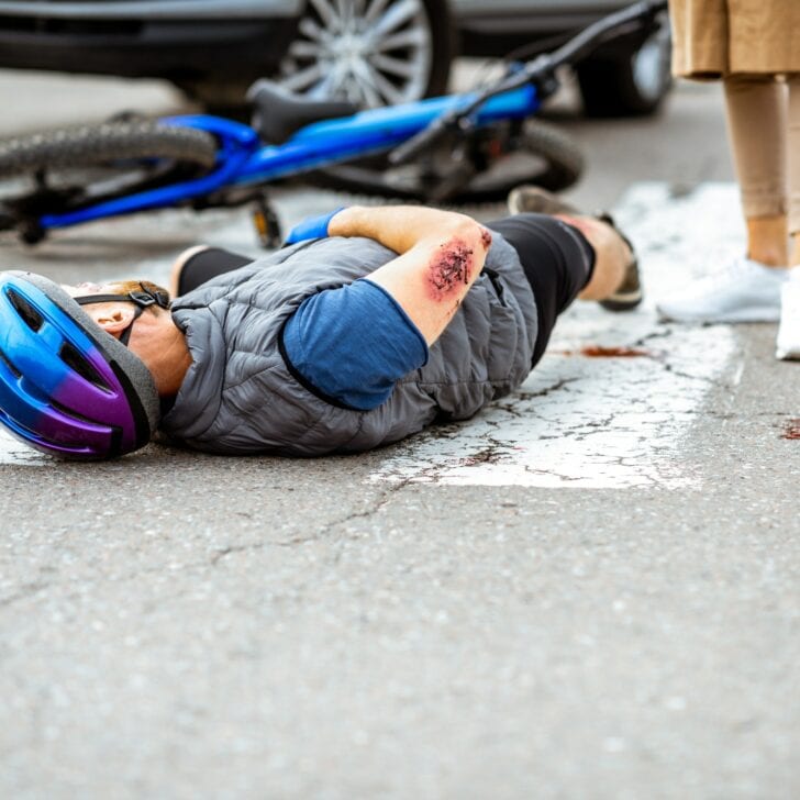 Road accident with injured cyclist and car