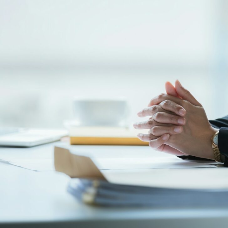 Close up clasped hands businesswomen negotiate at table, confrontation concept, negotiators