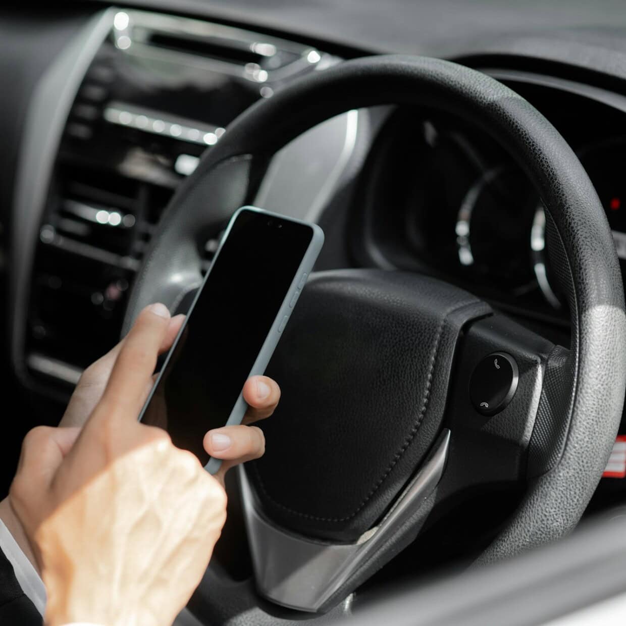 Man sits in the driver's car, he holds the phone and operates, traveling by car, driving safe, respe