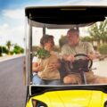 active elderly senior couple getting groceries on golf cart