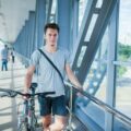 Handsome bicyclist standing on bridge