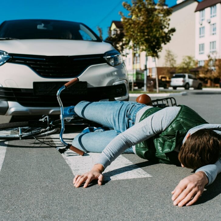 male bicycle rider hit by car on road, car accident concept