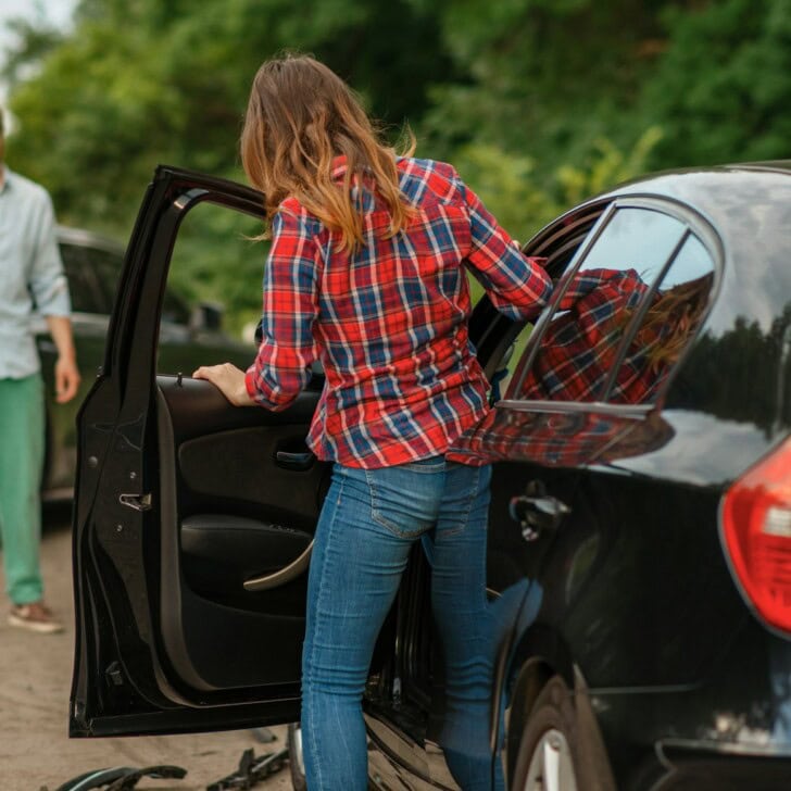 Male and female drivers after car accident on road