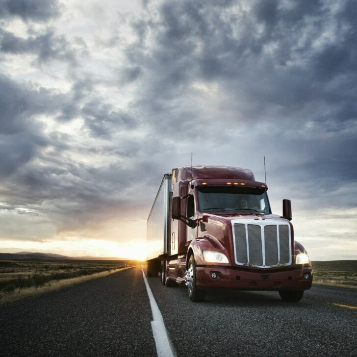 3/4 front view of a commercial truck on the road at sunset in eastern Washington, USA