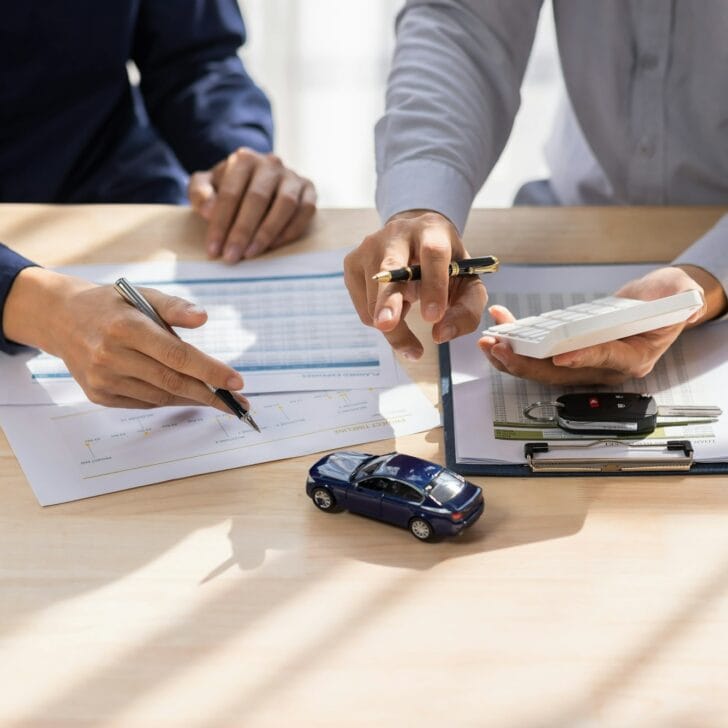 Car Insurance document or lease concept the car broker assisting his customer and explaining the