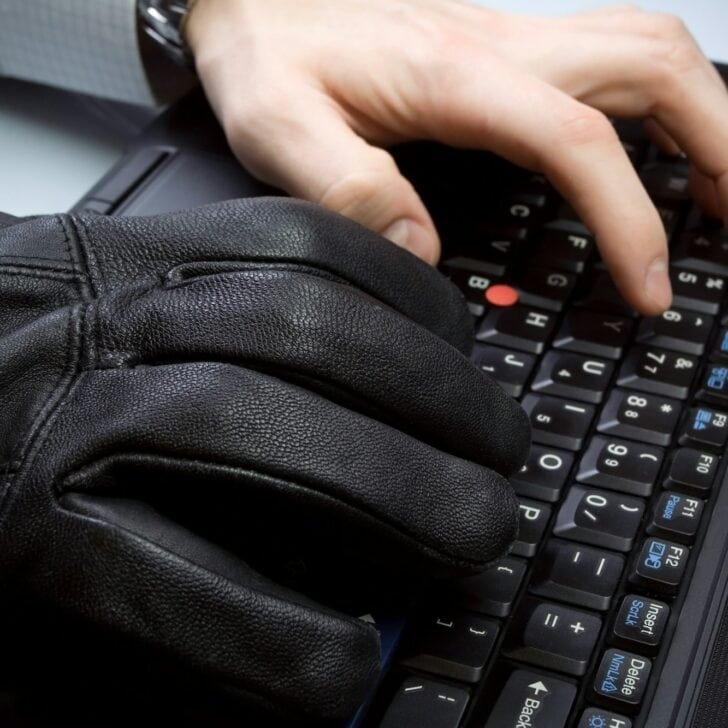 Computer theft with hands on laptop keyboard