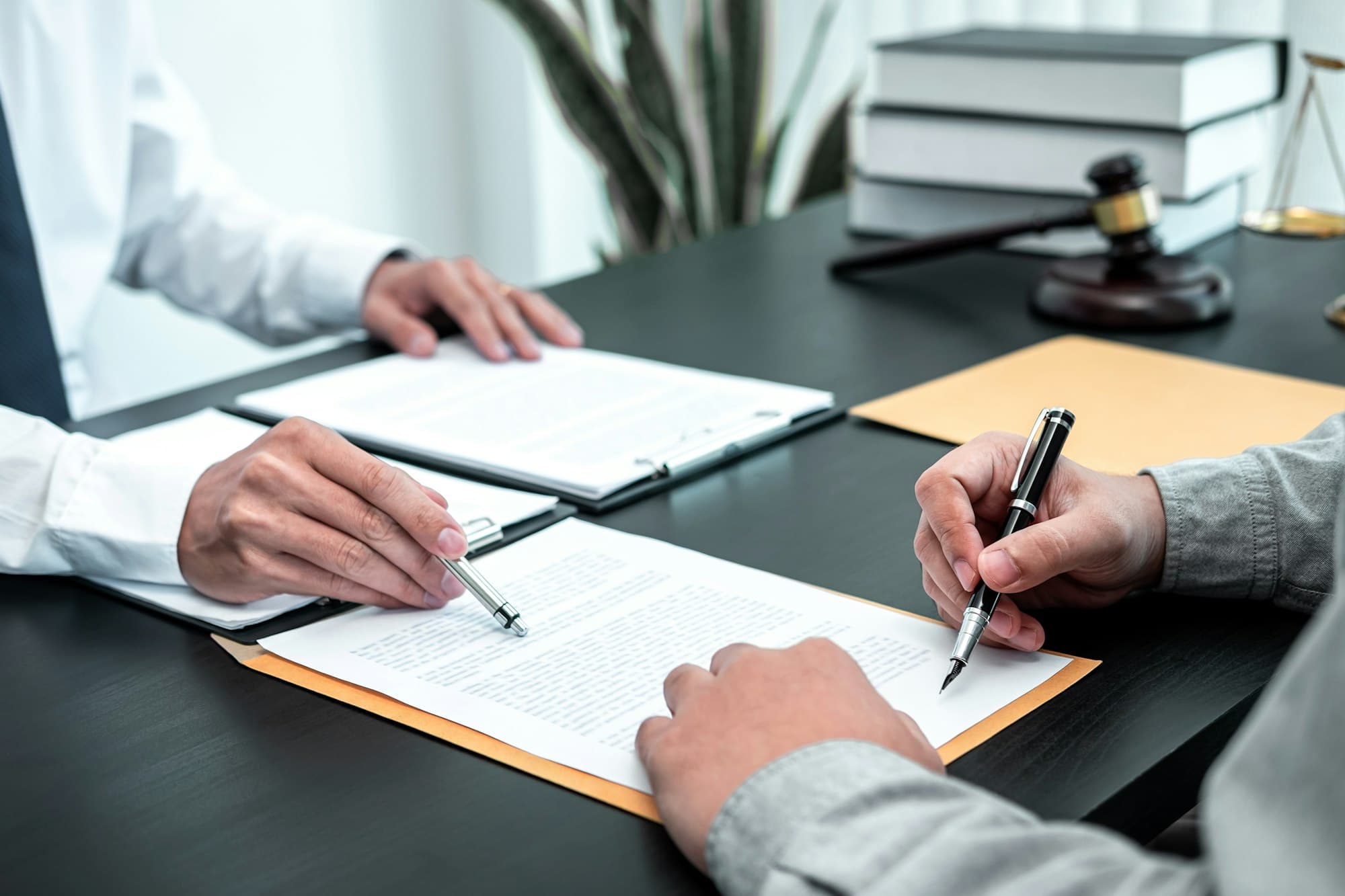 Male lawyer discussing negotiation legal case with client meeting with document contact in courtroom