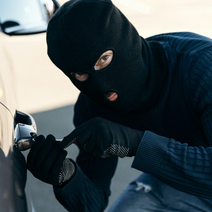 Thief trying to break into the vehicle, car thief trying to break into a car with a screwdriver