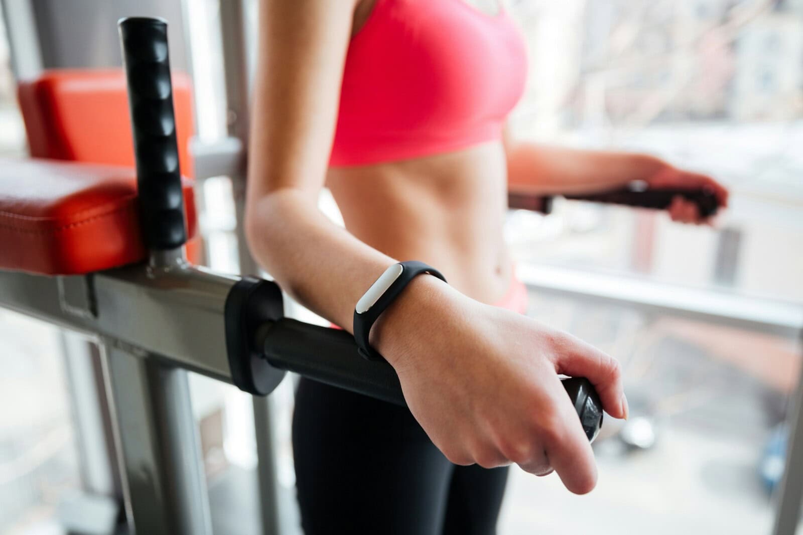 Woman athlete with fitness tracker on hand working out