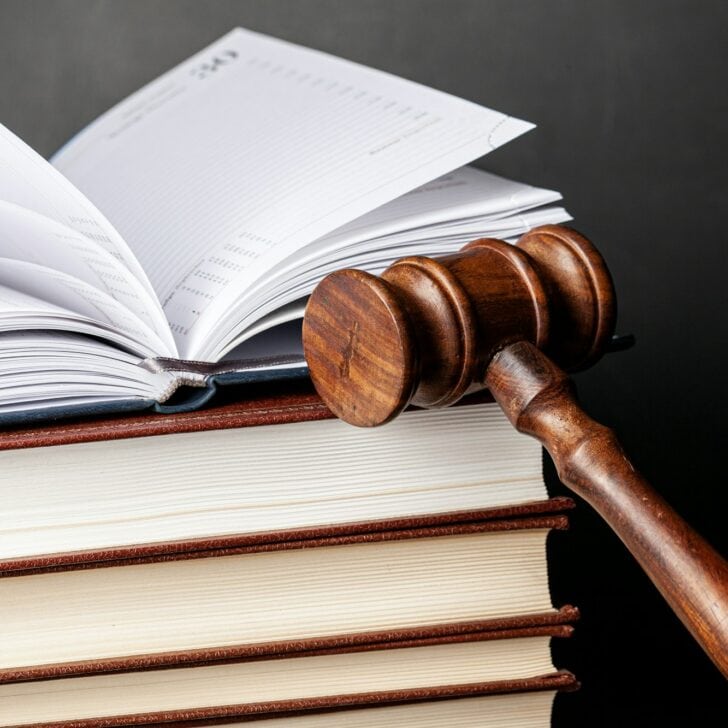 Wooden gavel and juridical books close up