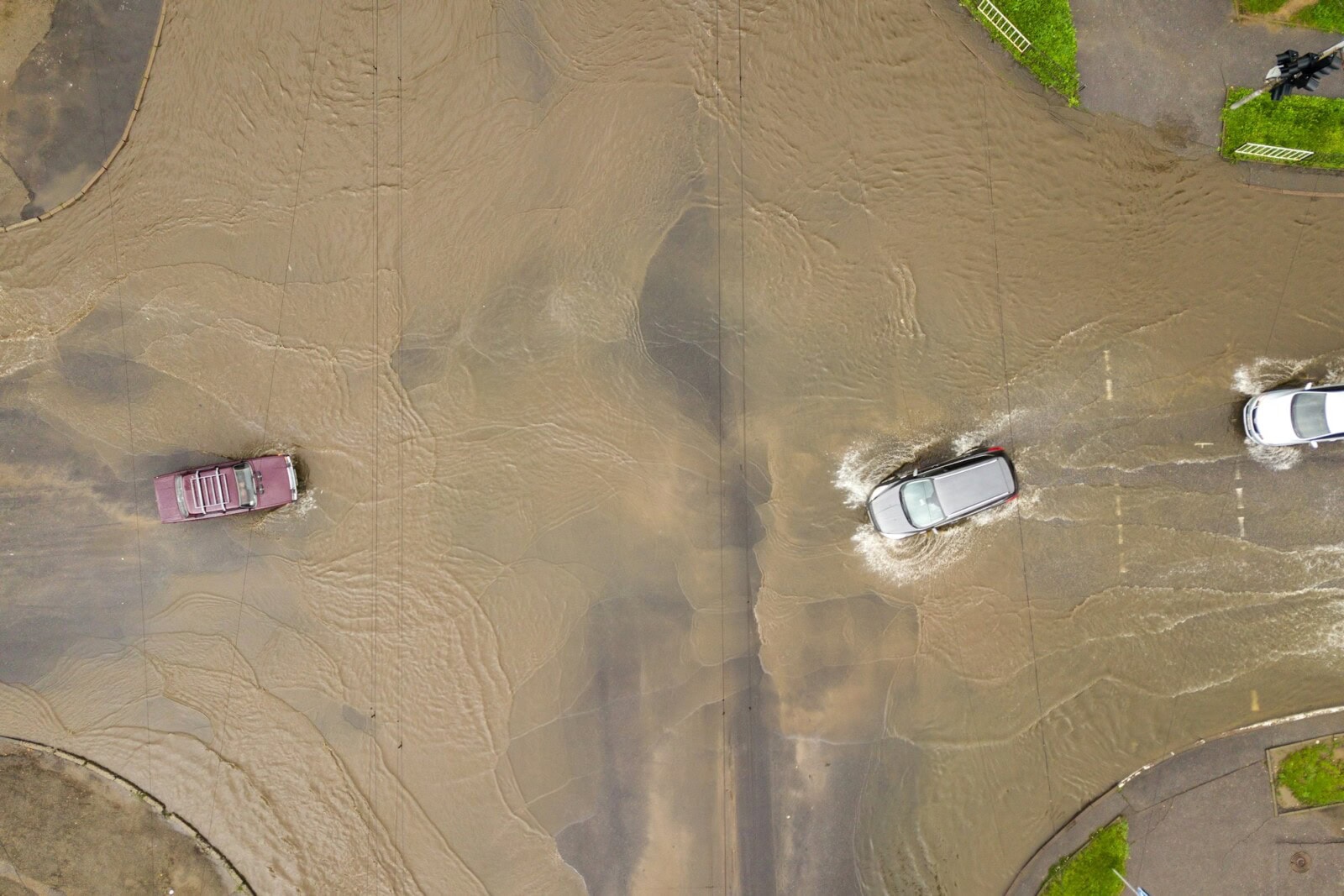 Aerial view of traffic cars driving on flooded road with rain water
