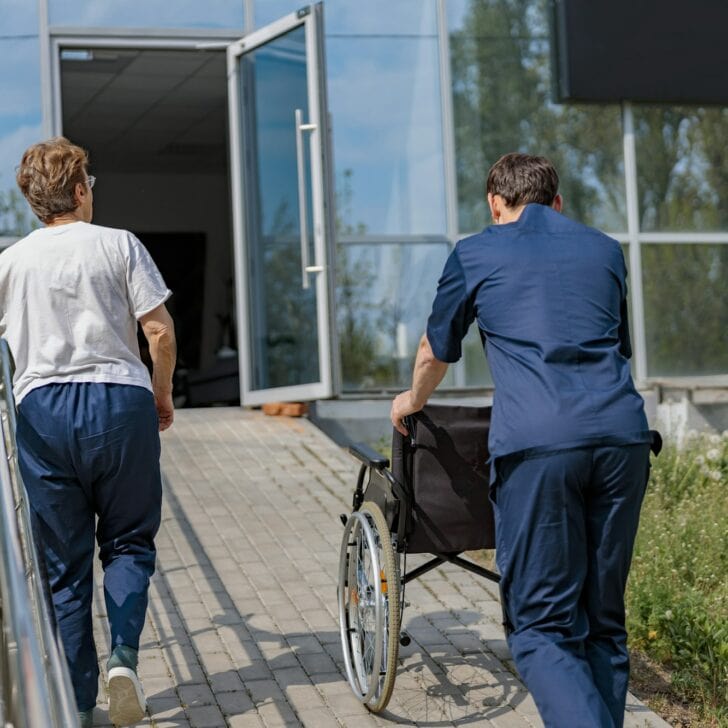 Patient and nurse turn around at clinic after a walk in courtyard