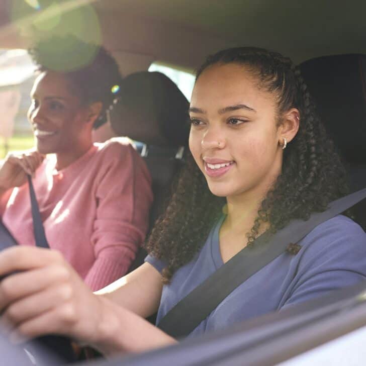 Teenage Girl In Car Having Driving Lesson From Female Instructor Or Parent