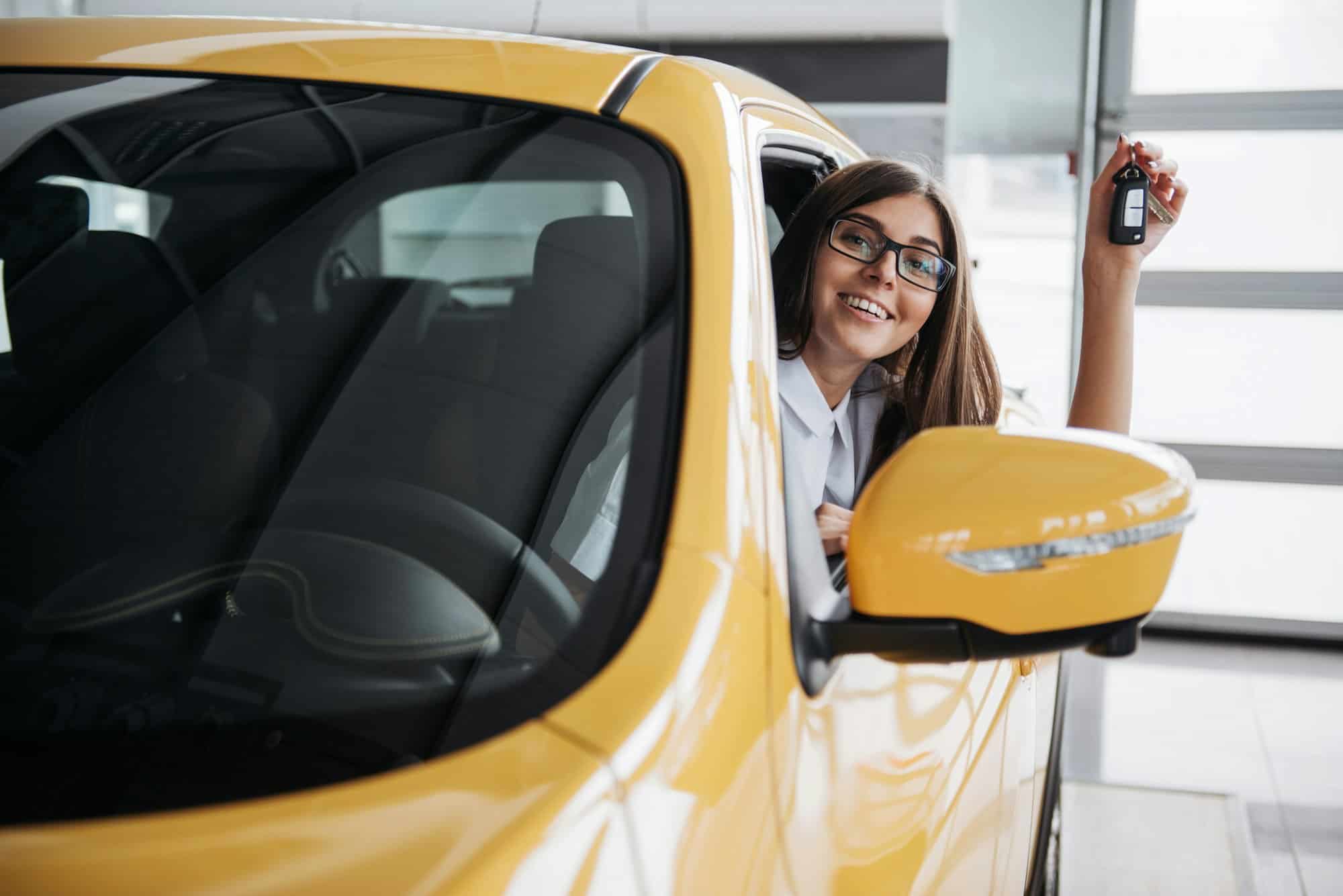 The woman driver smiling showing new car keys