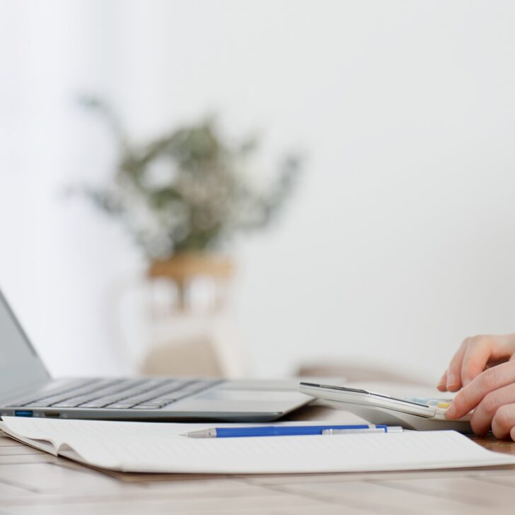 A woman calculating expenses with a calculator