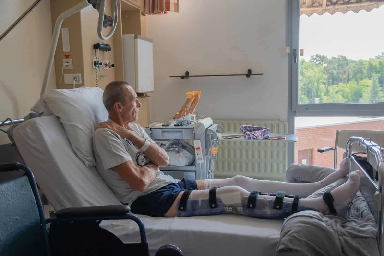 man with broken leg in an orthosis on bed in a clinic after an accident and a fracture of the femur