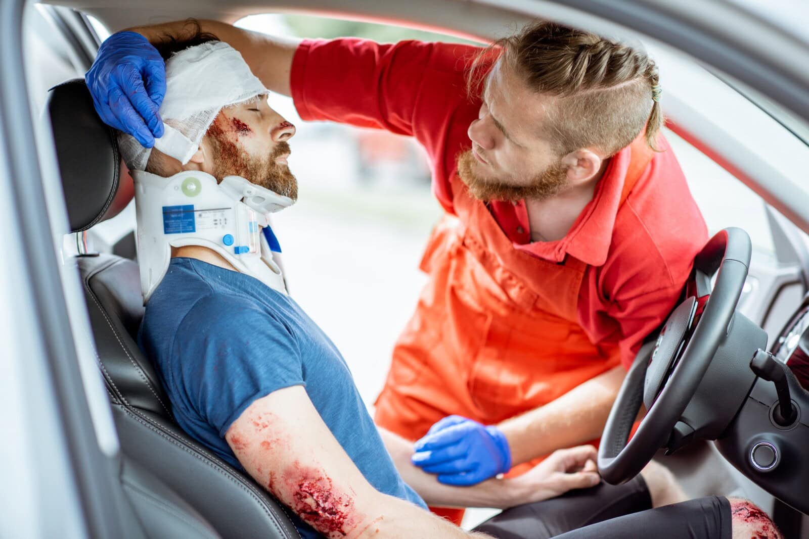 Medic providing emergency medical assistance after the road accident