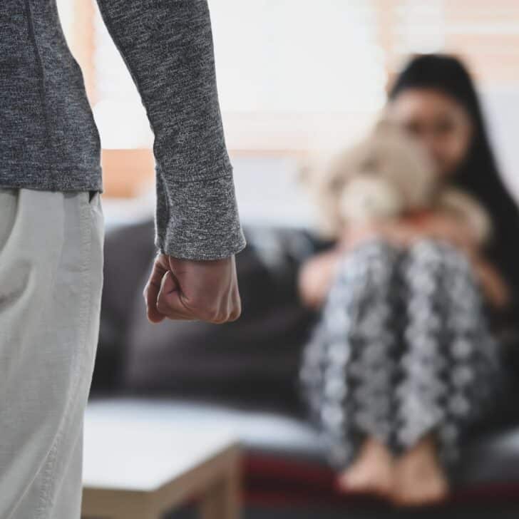 Aggressive man with clenched fist threatens to hit scared little girl.