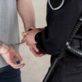 cropped shot of policewoman with truncheon handcuffing bandit