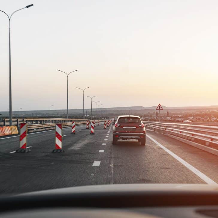 Passenger car driving on highway at dawn