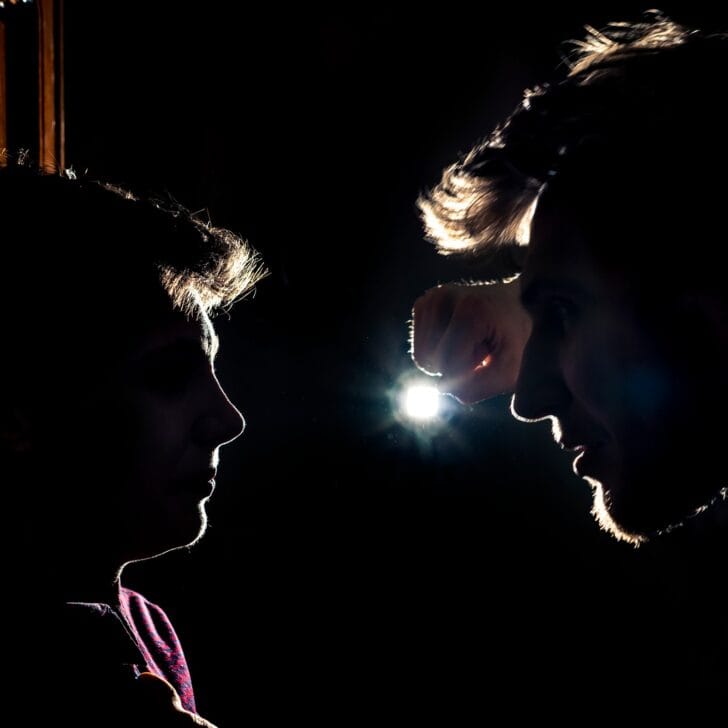 silhouette of two young guys in the dark place bully and fight conception