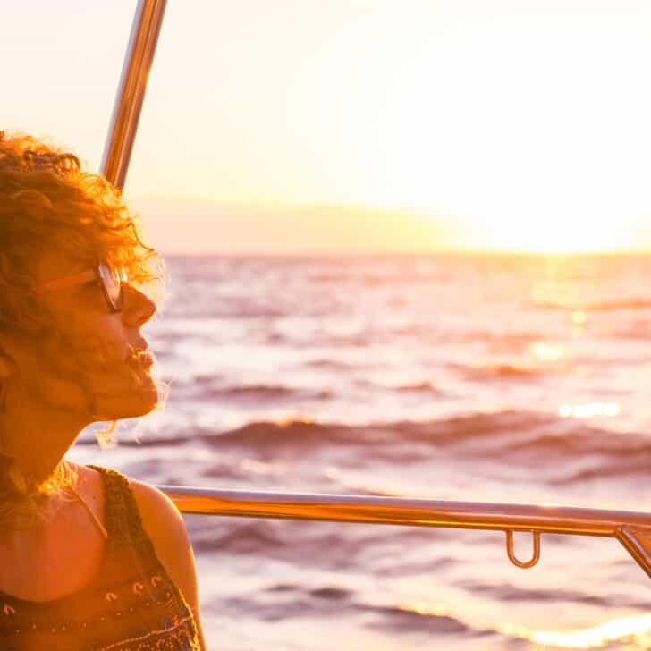 Portrait of a beautiful adult caucasian woman enjoying the sunset on the boat