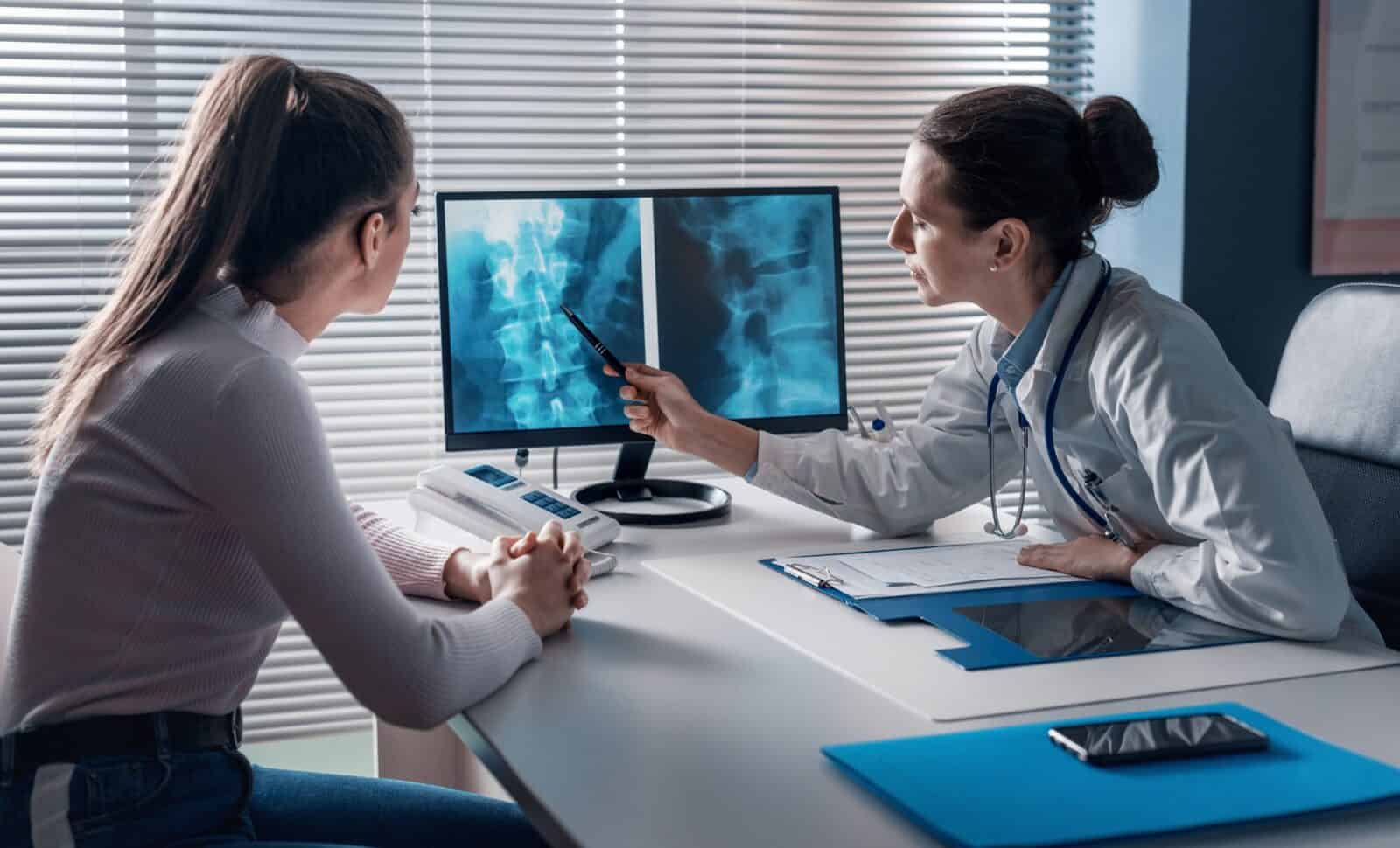 Doctor checking a patient's x-ray of spine