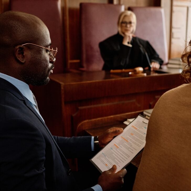 Focus on young confident attorney reading juridical document in court