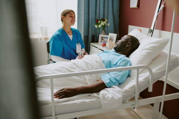 providing care to patient in hospital bed 600x400