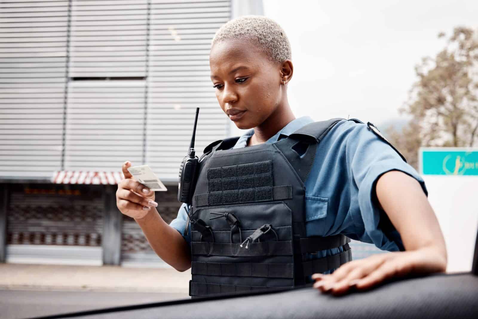Black woman, drivers license or police officer in city to check info for law enforcement, protectio